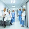 Ärzteteam und Pflegekräfte im Krankenhausflur – interprofessionelle Zusammenarbeit für moderne Patientenversorgung