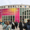 Besucher betreten Messe Berlin zur DMEA-Konferenz – großes Banner mit ‚Time to connect Digital Health‘ an der Gebäudefassade weist auf Veranstaltung zur digitalen Gesundheit hin