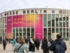 Besucher betreten Messe Berlin zur DMEA-Konferenz – großes Banner mit ‚Time to connect Digital Health‘ an der Gebäudefassade weist auf Veranstaltung zur digitalen Gesundheit hin