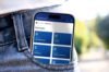 Smartphone in der Gesäßtasche einer Jeans zeigt die Startseite der KIDICAP-App mit Dokumentenübersicht (Postfach, Gehalt, Lohnsteuer, Sozialversicherung).